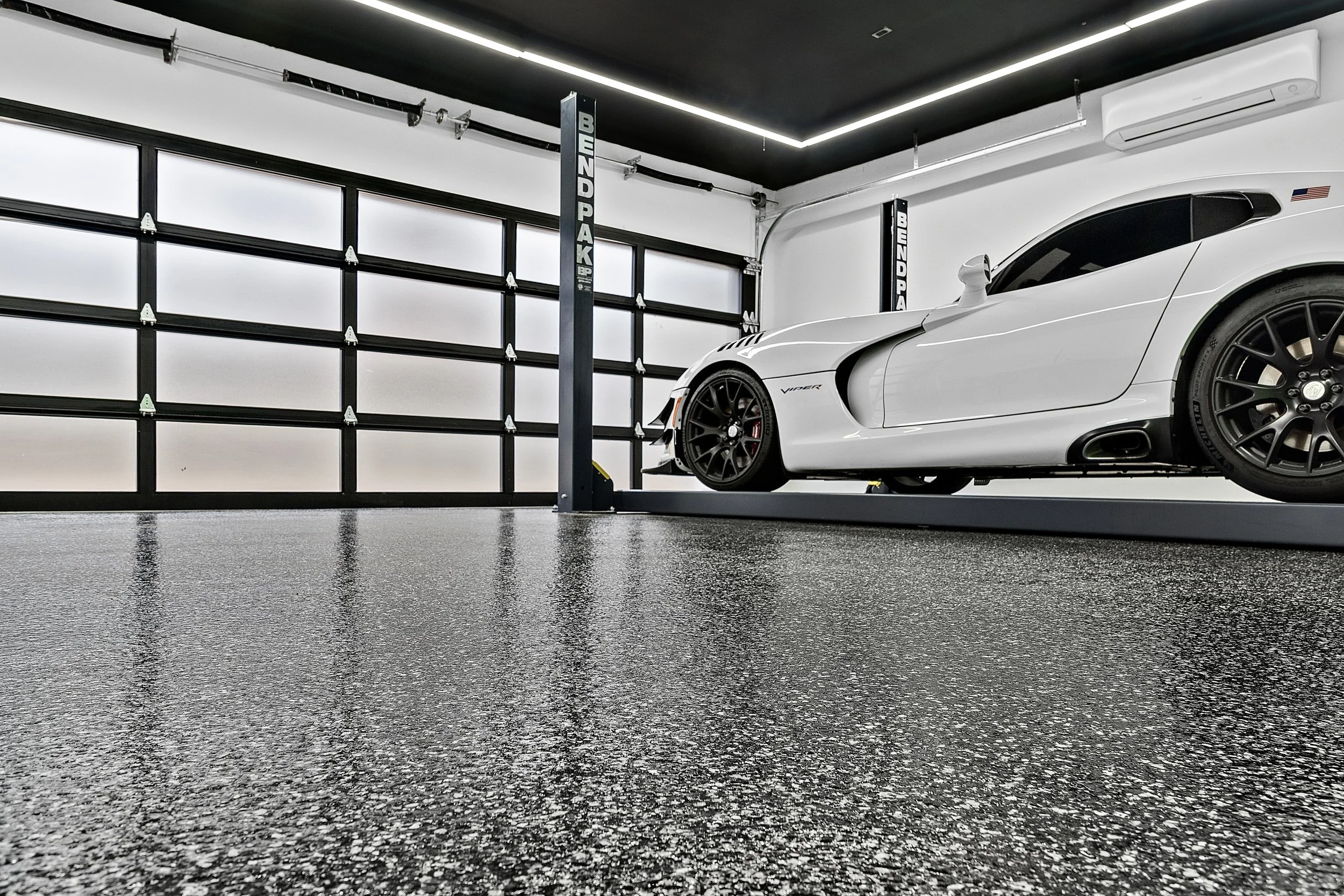 Clean finished gray flake epoxy garage floor with organized storage