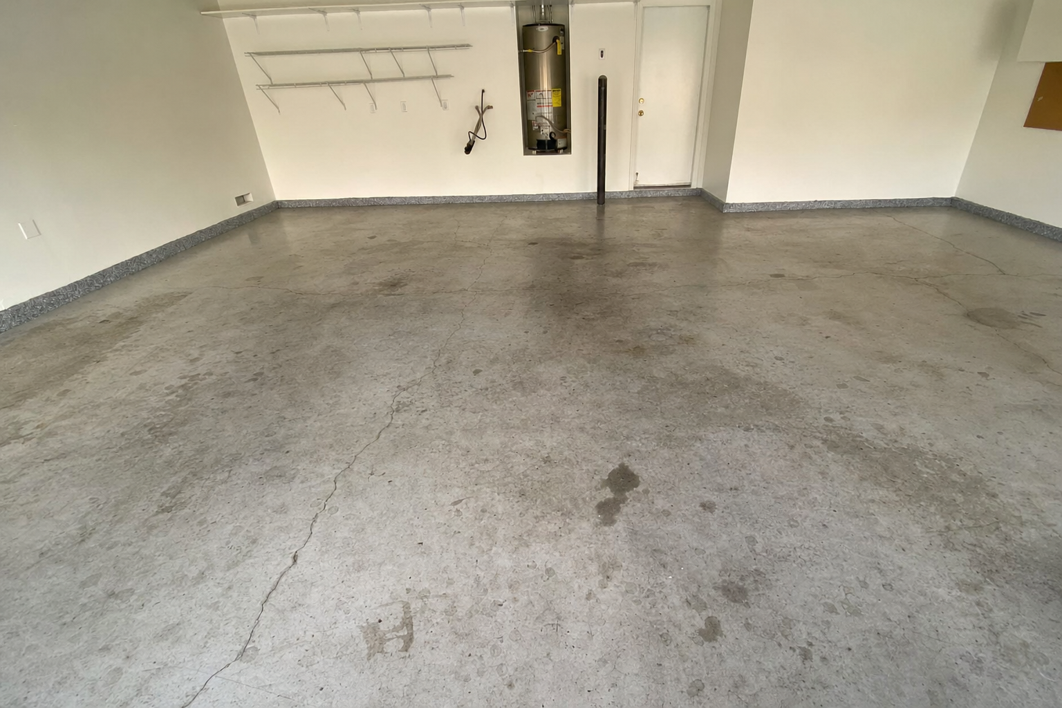 Garage floor before epoxy coating - stained bare concrete